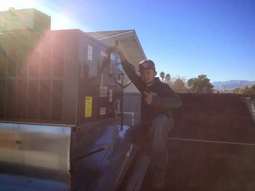 HVAC technician performing HVAC Inspection on a rooftop unit in Maplewood